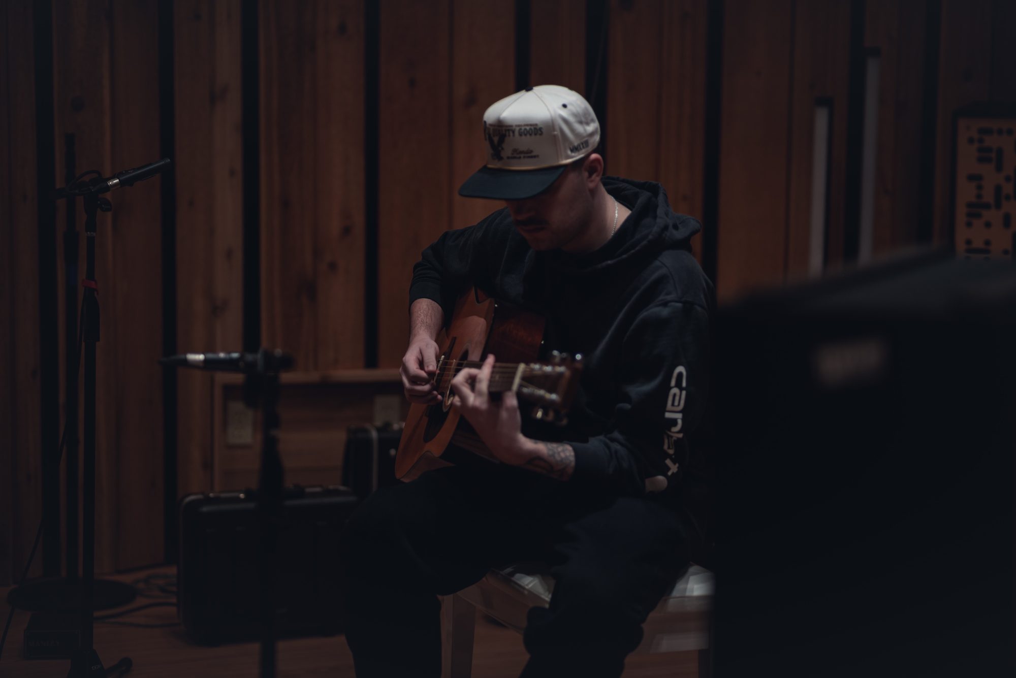 Matt Mueller playing acoustic guitar in the studio