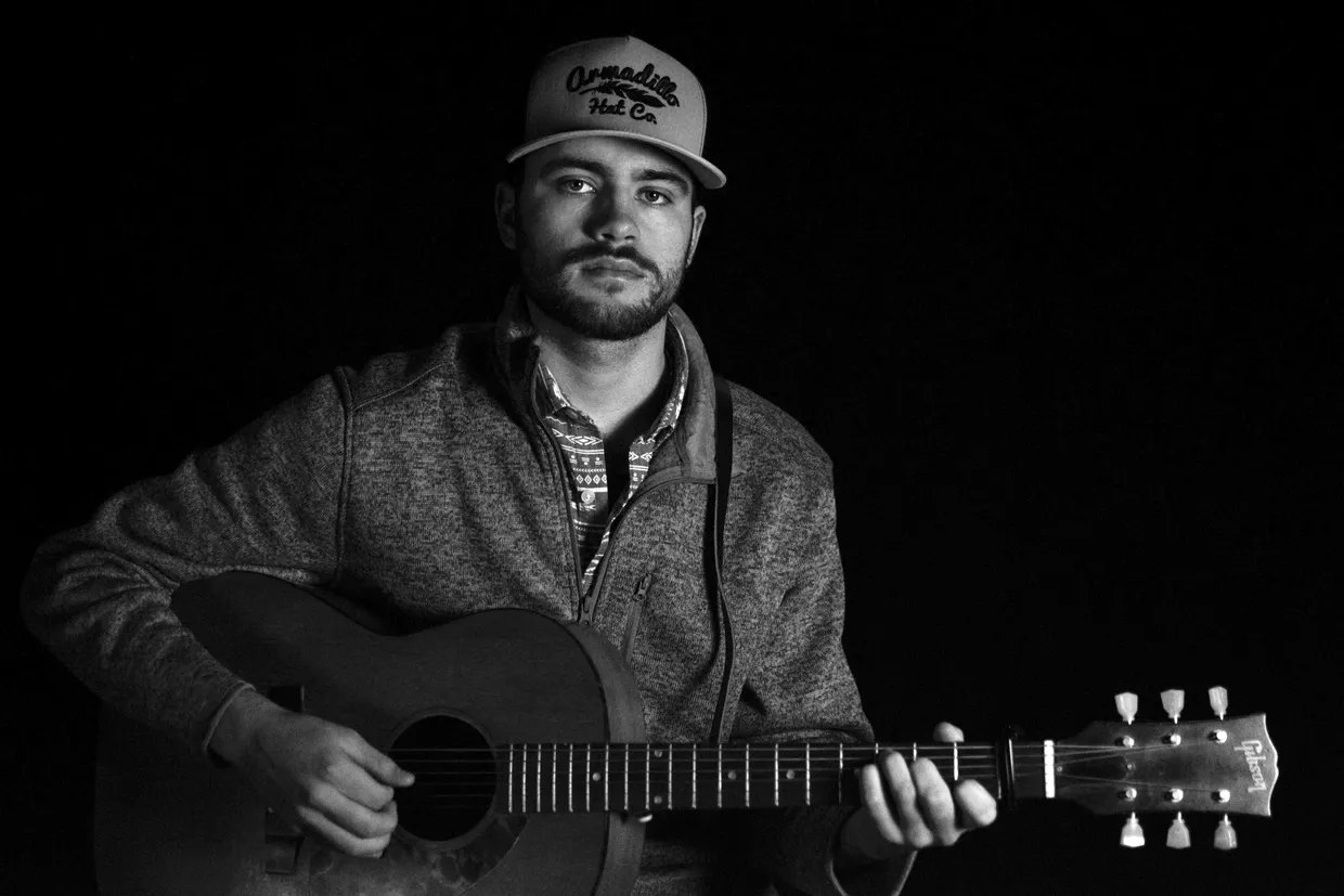 Black and white portrait of Matt Mueller with guitar